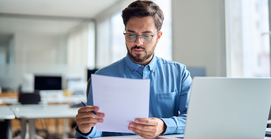 Property manager vérifiant des documents de bail dans un espace de bureaux professionnel